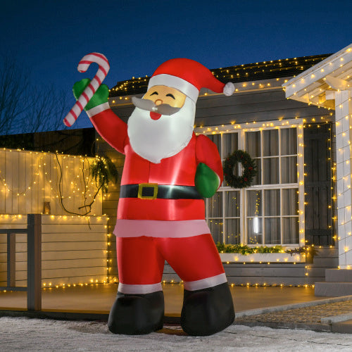 Inflatable Santa Claus holding a candy cane in front of a house decorated with Christmas lights.