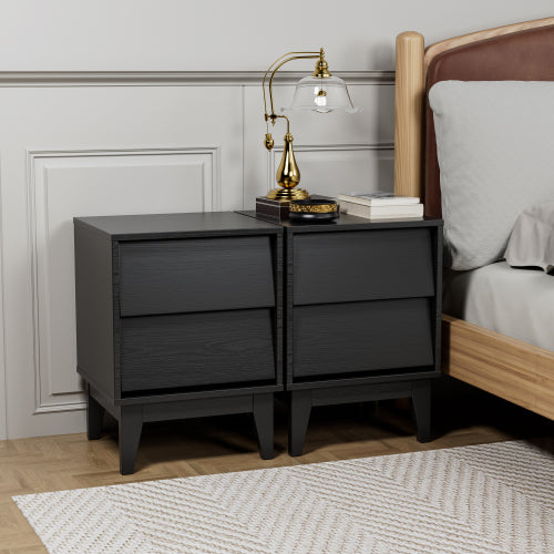 Black nightstand with gold lamp next to a bed in a bedroom setting