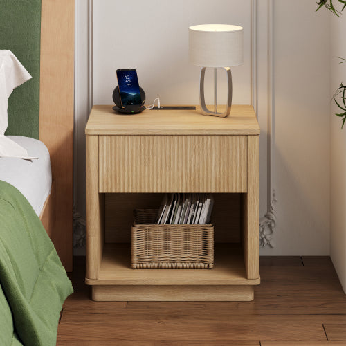 Wooden nightstand with lamp, phone, and books in a bedroom setting